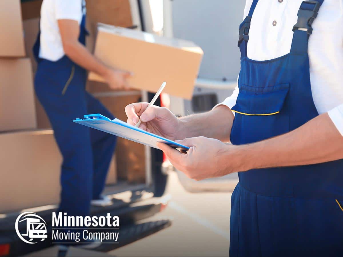 Movers from Minnesota Moving Company handling boxes and taking notes, specializing in Local & Long Distance Moving